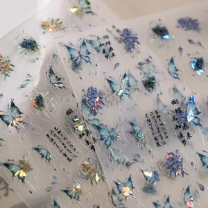 Detalle macro de pegatinas de uñas PET con mariposas acuarela azules y motivos láser plata