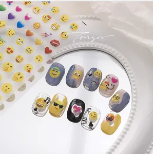 Detailed view of colorful emoji nail art stickers applied on clear manicure tips