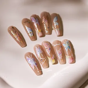 Detail of handmade nude pink press-on nails with 3D gradient butterflies and rhinestones