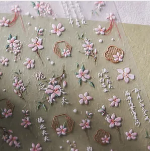 Macro detail of embossed peach blossom nail stickers with Chinese calligraphy text