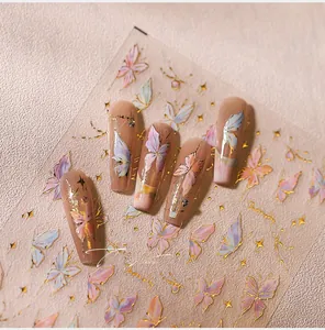 Macro detail of nude butterfly press-on nails with gold foil and purple gradients