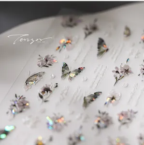 Macro detail of holographic 3D embossed nail stickers with laser butterfly and flower patterns