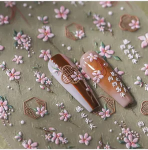 Detailed close-up of 5D embossed pink peach blossom nail stickers with Chinese calligraphy