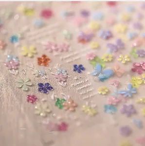 Macro shot of 3D embossed colorful floral and butterfly nail art stickers in macaron tones