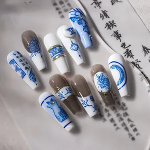 Detailed view of blue and white porcelain nail art with floral patterns and calligraphy