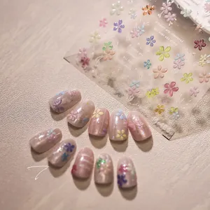 Macro view of 3D embossed jelly floral nail stickers and finished pink glossy manicure