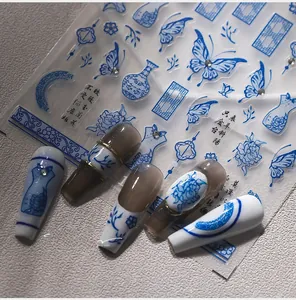 Macro detail of blue porcelain style nail stickers with bows and floral patterns