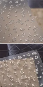 Detailed macro of 3D embossed silver rose nail art stickers with metallic texture
