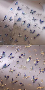 Détails macro des autocollants ongles papillon irisés avec motifs étoiles dorés