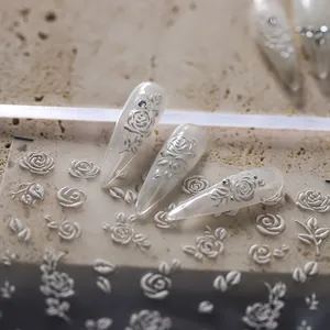 5D embossed rose nail stickers with elegant white floral patterns on false nails