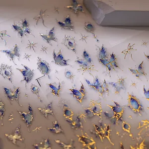 Autocollants ongles papillons bleus avec dorure et motifs d'étoiles scintillantes sur pierre