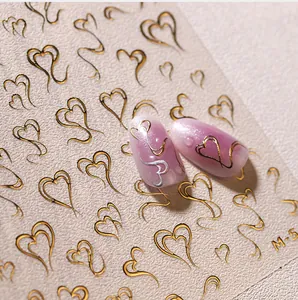 Macro shot of 3D embossed gold heart nail stickers with pink gradient almond fake nails