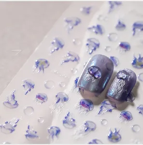 Détail de stickers 3D méduse avec bulles bleues sur effet de manucure œil de chat violet