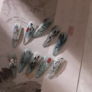 Detail view of ink butterfly press-on nails with bamboo motifs on calligraphy paper