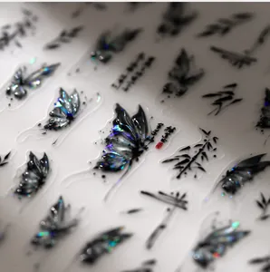 Macro detail of laser holographic butterfly and bamboo nail stickers with ink wash style