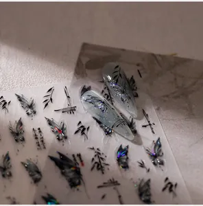 Macro detail of black butterfly nail art stickers with iridescent glitter on grey nails