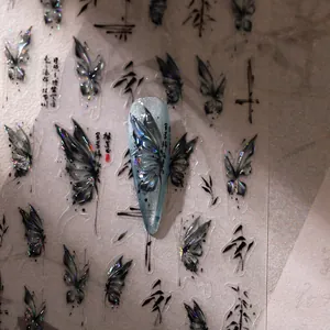 Detailed macro view of laser butterfly nail stickers with Chinese ink art elements