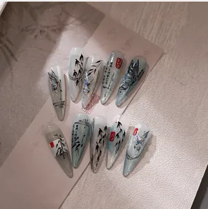 Macro detail of hand-painted ink butterfly and bamboo pattern on stiletto press-on nails