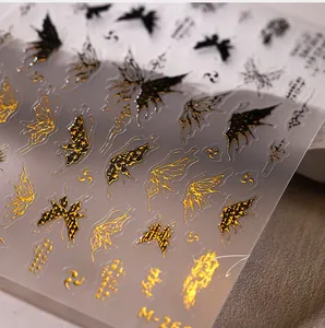 Close-up of black and gold 3D butterfly nail art stickers with metallic embossed details