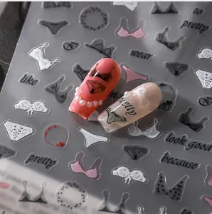 Detail of 5D nail art stickers featuring lingerie motifs and artistic lettering