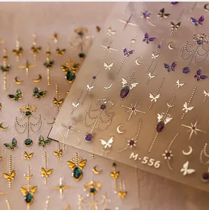 Macro detail of M-556 3D embossed nail stickers with gold butterfly and moon designs