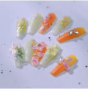Macro detail of handmade press-on nails with 3D resin flowers and crystal rhinestones