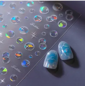 Detail showing holographic laser bubble nail stickers and finish on blue manicured nails