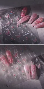 Close-up of 3D aurora butterfly and tulip nail art stickers showing pearl texture