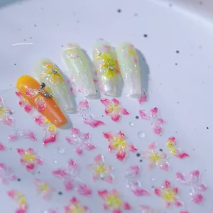 Detailed macro view of 3D embossed floral nail art stickers with pink pearl finish