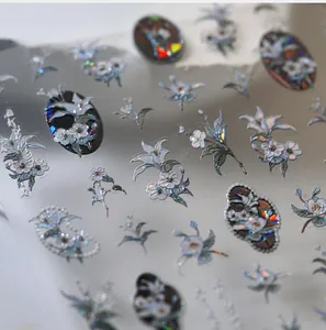 Détail macro d'autocollants holographiques pour ongles avec fleurs de lys irisées