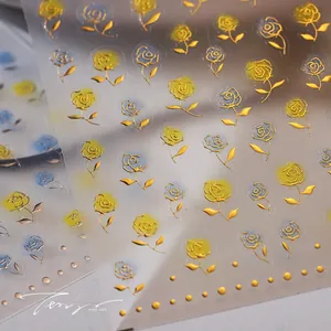 Macro view of gold foil rose nail stickers with 3D embossed texture and gradient details