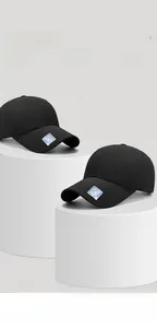 Detailansicht zweier schwarzer atmungsaktiver Basecaps mit holografischem Logo auf Sockeln