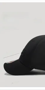 Détail d'une casquette noire avec bord court de 5,5 cm et tissu texturé