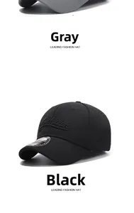 Detail of grey and black short-brim baseball caps with laser-cut holes and embroidery