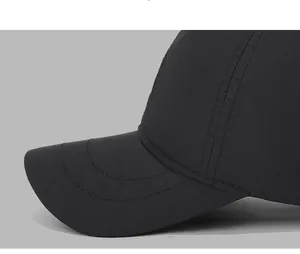 Close-up of reinforced stitching and matte black waterproof fabric on a baseball cap