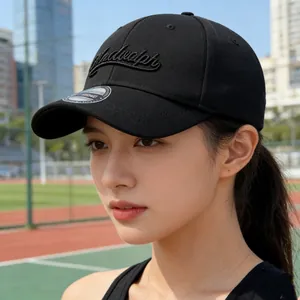Casquette de baseball noire à broderie 3D sur fond de piste de sport en extérieur