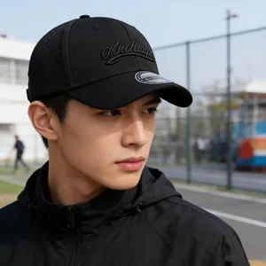 Short brim baseball cap with embroidery detail and windproof hoodie in outdoor setting