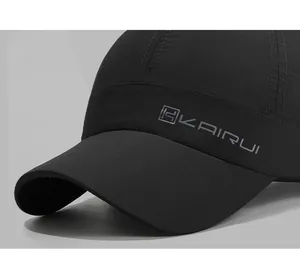 Close-up of quick-dry baseball cap featuring gray KAIRUI embroidery on black fabric