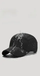 Macro shot of water droplets on waterproof black baseball cap fabric showing quick-dry texture