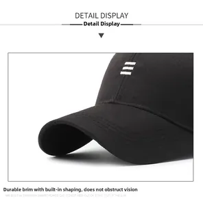 Detailed close-up of the reinforced brim and embroidery on this black cotton baseball cap