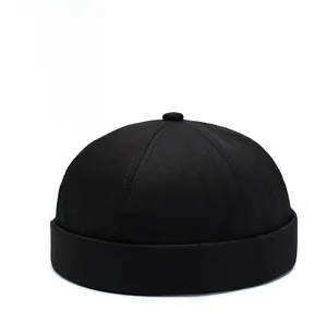 Detail of a black cotton brimless docker cap featuring six-panel construction and folded edge