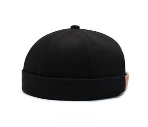 Side view detail of a black canvas docker hat with vintage brown leather strap