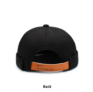 Detail of black brimless docker hat with adjustable brown leather strap and logo