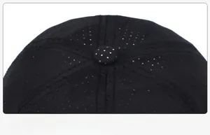 Detail view of a black baseball cap top showing ventilated fabric and a secure metal rivet