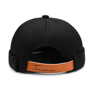 Unisex black brimless docker cap with textured twill fabric and brown leather strap