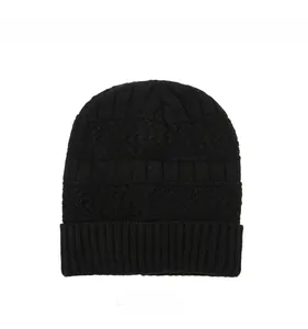 Détail du bonnet en tricot noir avec motif texturé et étiquette grise avec texte Jeans