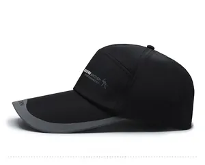 Detail view of long-brimmed black baseball cap with side letter printing and athletic logo