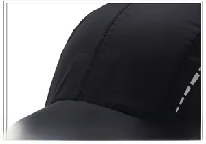 Détail de la casquette de sport noire à séchage rapide avec logo brodé et bande réfléchissante