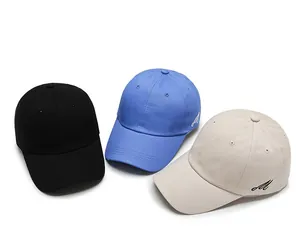 Détail de casquettes de baseball en coton avec broderie M en noir, bleu et beige clair