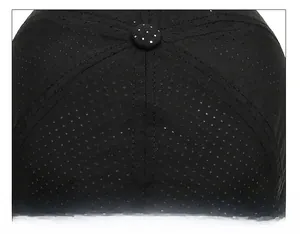 Detailed macro view of black mesh baseball cap showing top button and quality stitching